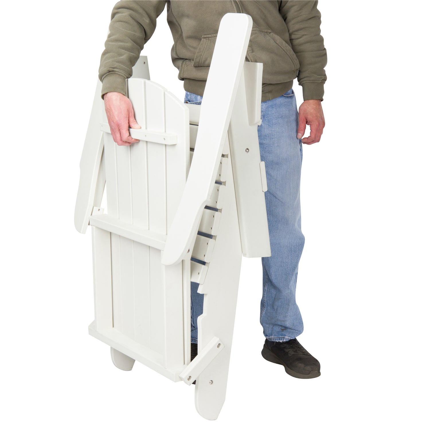 A person in a brown hoodie, blue jeans, and black shoes is holding a white folding patio chair against a plain white background. 