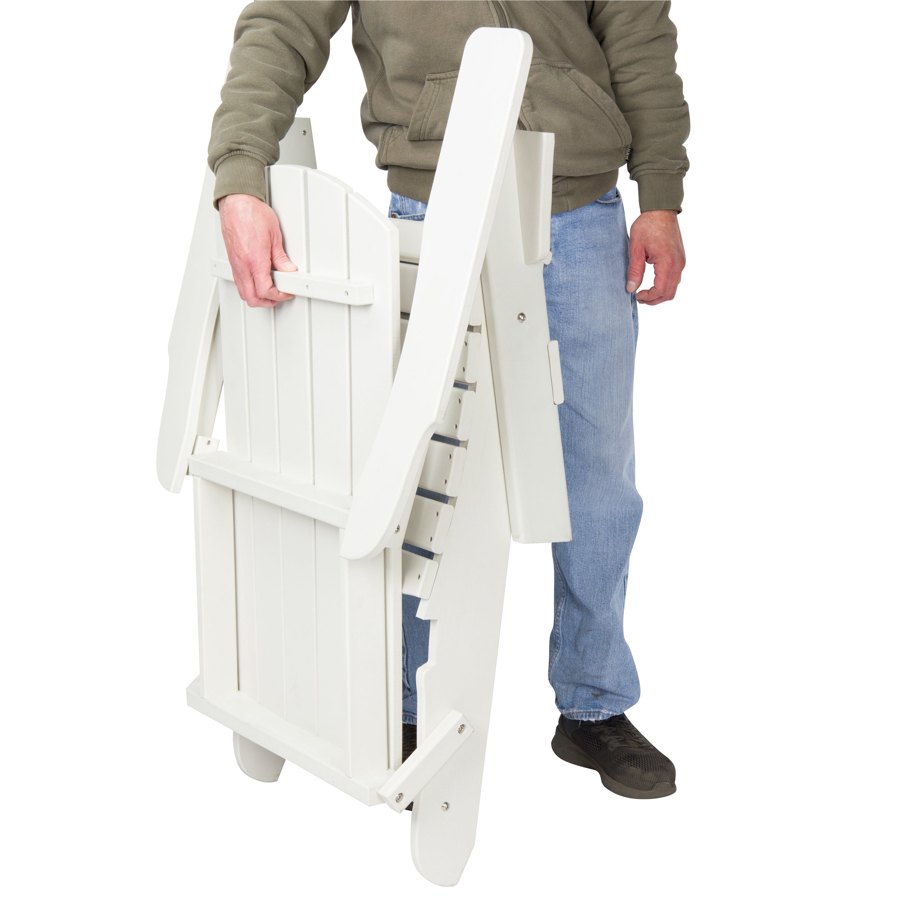 A person in a brown hoodie, blue jeans, and black shoes is holding a white folding patio chair against a plain white background. 